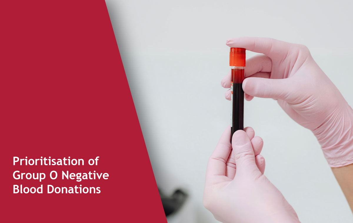 Gloved hands hold a blood sample vial with a red cap, against a light background; maroon left panel displays the title 'Prioritisation of Group O Negative Blood Donations'.