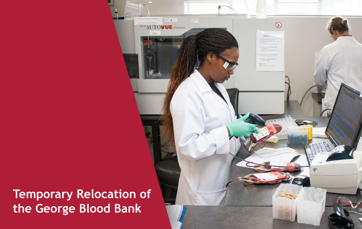 Lab technician in a white coat and green gloves handles blood samples at a busy workstation with a laptop nearby during relocation.