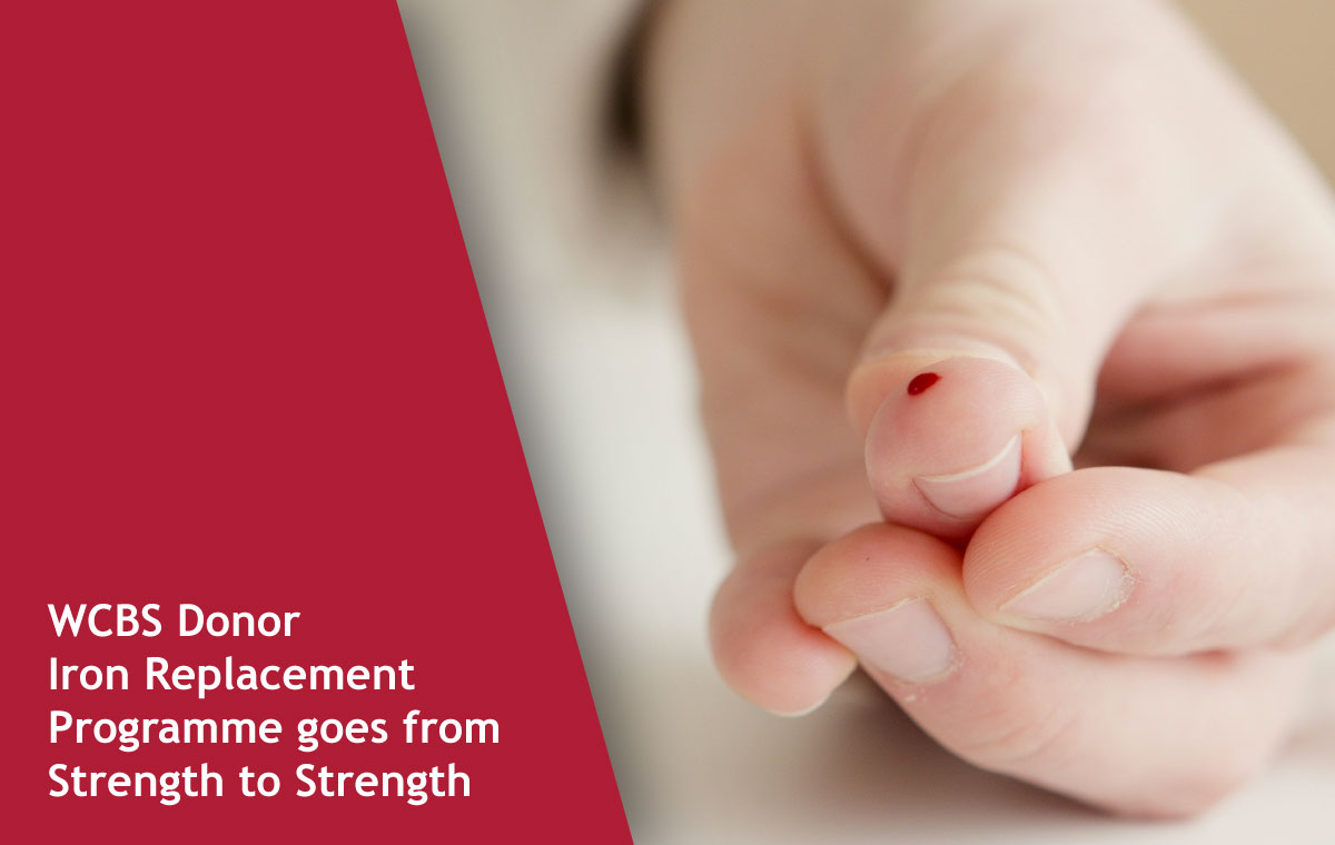 Close-up of a fingertip with a small drop of blood, set against a maroon banner announcing WCBS Donor Iron Replacement Programme goes from Strength to Strength.